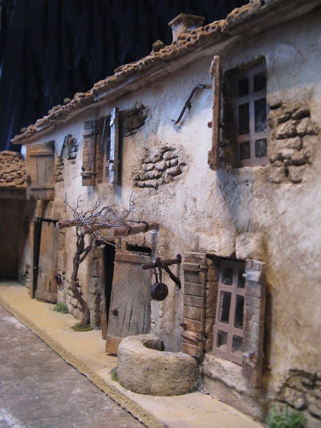 façade d'une ferme avec le puits ancien et la treille devant la maison